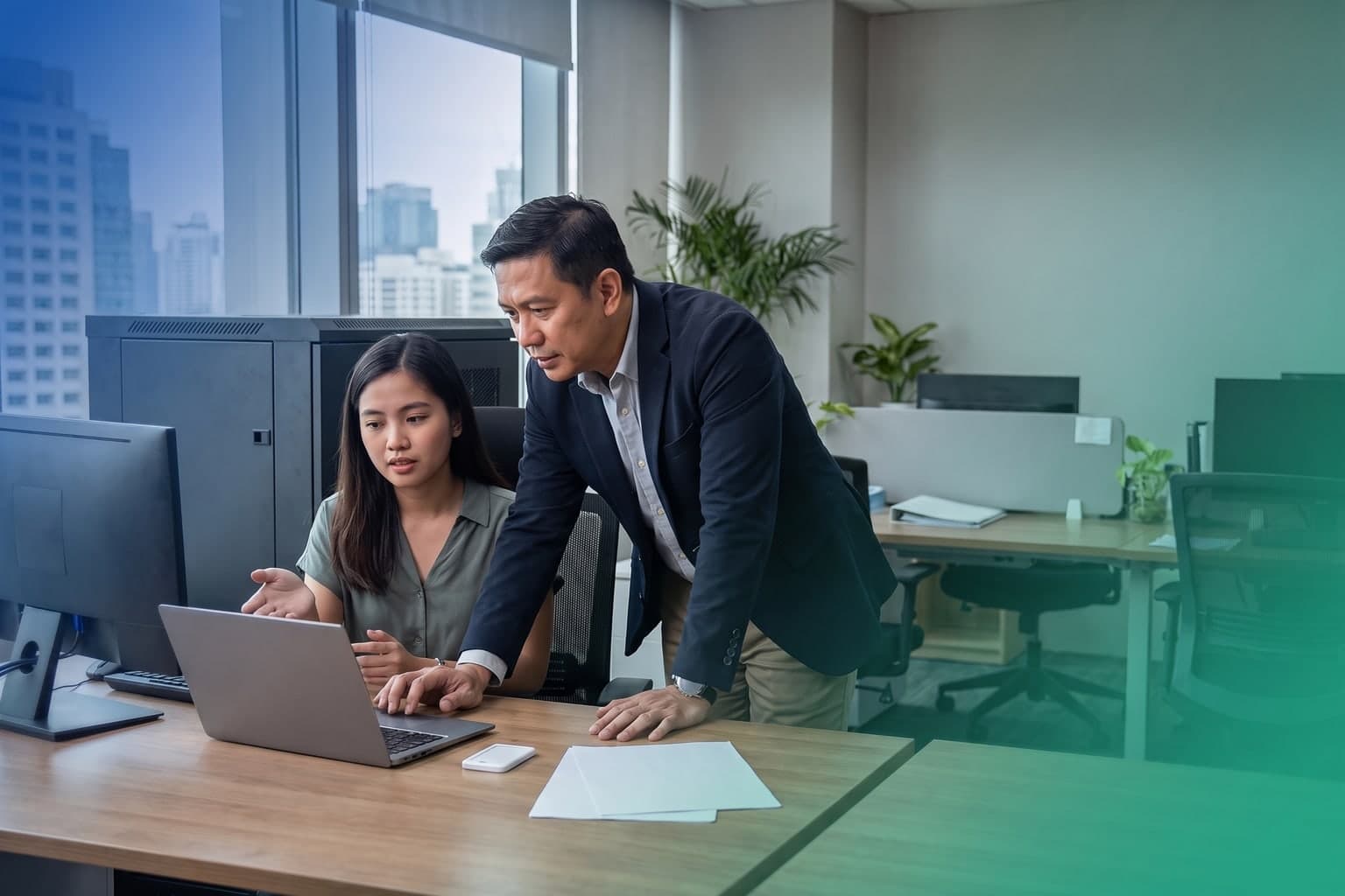 Two Filipino security professionals reviewing a laptop beside a server cabinet in a blue-and-teal Metro Manila office
